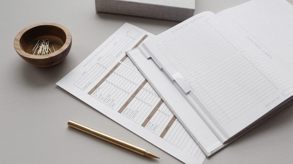 Documentos e caderno de contabilidade sobre uma secretária